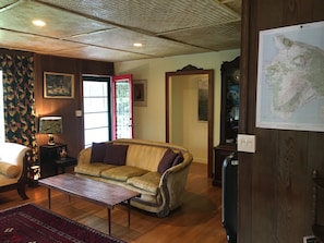 Living room is furnished with antiques and unique island art