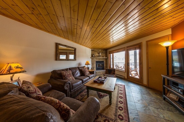 Living Room with wood burning fireplace and balcony looking at the ski resort.