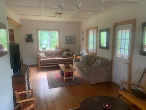 Open living space with beautiful wood floor, wood trim and natural light