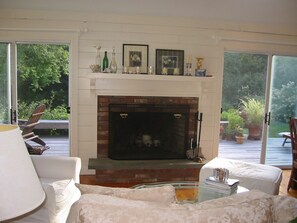 Great room fireplace with view to deck and yard