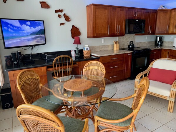 Open concept kitchen, dining area, and living room, includes a new TV.