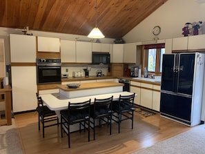 Large, fully applianced kitchen. View from dining area.