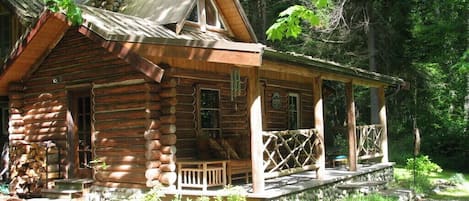 Charming cabin with covered front porch sitting area.