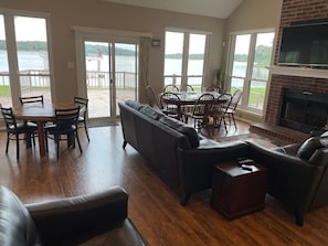 Living and dining area with beautiful lake view.  Large screen TV above mantel.