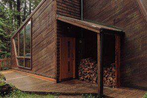 Cabin entrance is stocked with dry firewood.