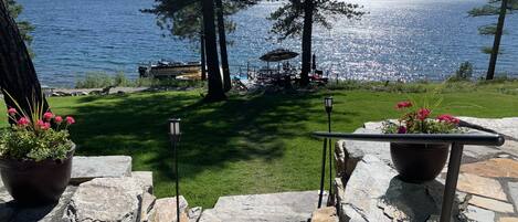 Stone staircase to the lawn. Upper level patio with flagstone.