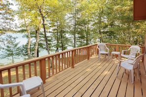 Enjoy the deck overlooking the lake and trees on both sides of the cabin.