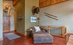 Comfy reading loveseat under bison & caribou mounts and Peter Corbin artwork