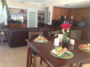 ENTERTAINMENT CENTER VIEWED FROM 2 LARGE SOFAS IN  DEN, KITCHEN & DINNING AREA
