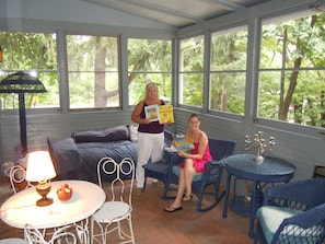 Owner & friend sharing favorite children's book on porch.
