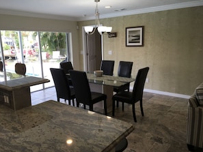The dining room with the pool outside the sliding glass doors that open to 9'