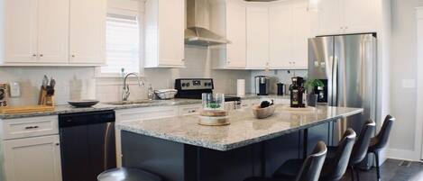 Kitchen island with four modern leather barstools. 