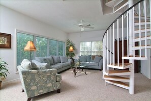 Living room with a spiral staircase to master suite and elevator