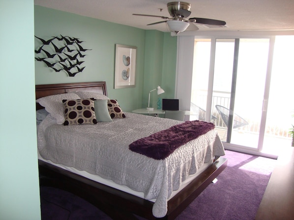 queen primary bedroom with ocean front balcony, modern desk and chair