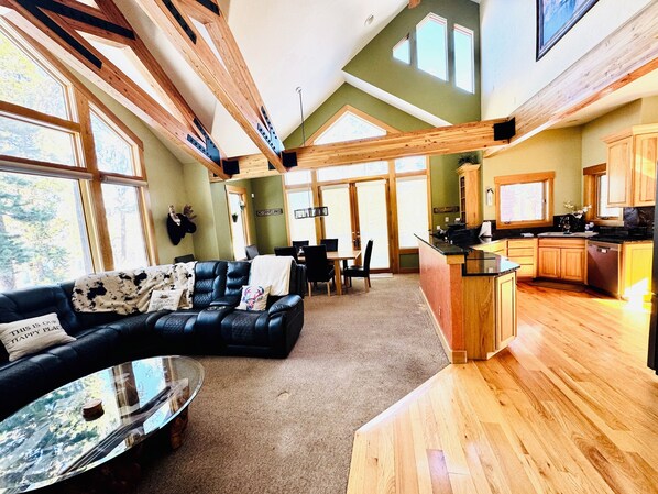 Open floorplan living room with access to kitchen, dining room, bathroom, patio