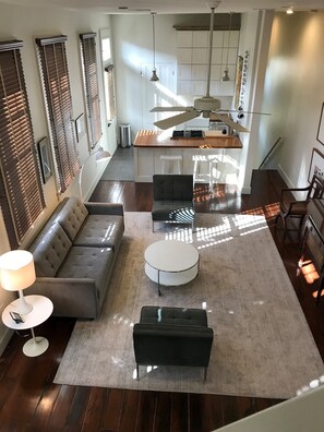 View of living room & kitchen (with fridge and washer/dryer behind) from stairs