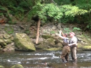 Annie with a nice fish on behind the Brookie Cottage