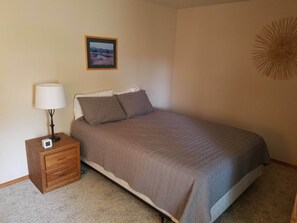 Bedroom with one queen bed and twin bunk beds