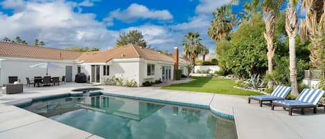 Rear of home with pool & spa and large yard.