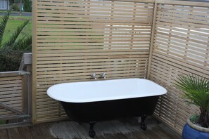 Outdoor bathtub on back deck. 