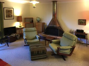 Cosy lounge area with 70's classic copper hooded open fireplace