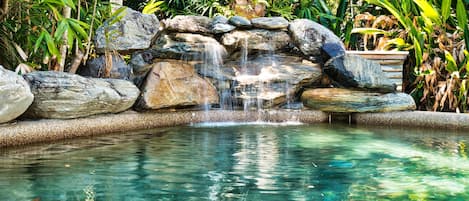 rejuvenating pool  in natural setting has a water fall