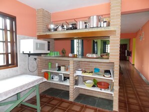 Casa para 15 pessoas: Cozinha com fogão, geladeira, microondas e utensílios.