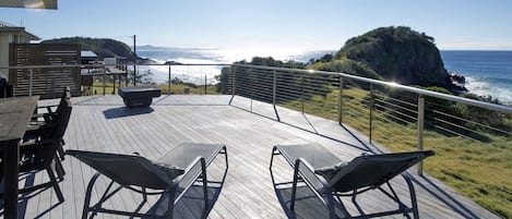 Oversized deck with views to Nambucca, outdoor table setting and lounge chairs