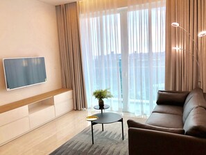 Living room with smart TV & dining area.