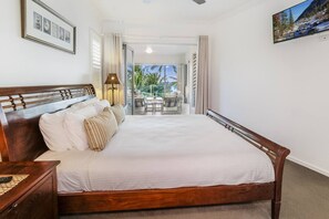 Rest easy in the primary bedroom, offering a plush king bed, wall-mounted TV and direct access to the balcony.