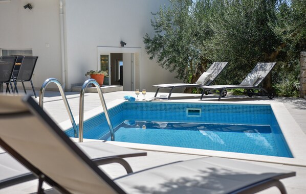 Heated pool, sun chairs, outdoor shower and place to grill.