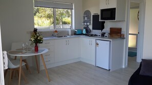 Kitchen with 2 hob stove, kettle, toaster, fridge, plunger & dining table