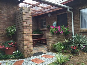 Garden leading to undercover patio and door