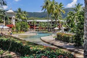 The resort's pool is a stunning, palm-lined oasis, offering ample space for the kids to play or to lay out and soak up the balmy Queensland weather.