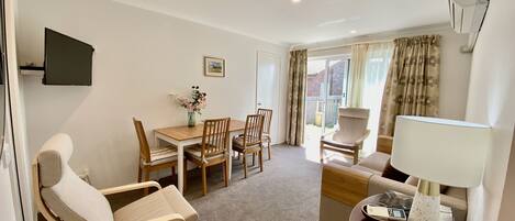 Living room with eating area for 4 and access to garden through sliding door.