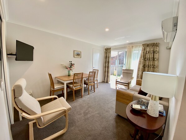 Living room with eating area for 4 and access to garden through sliding door.