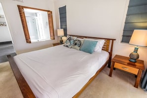 The primary bedroom is set with a comfortable king bed and offers direct access to the balcony.