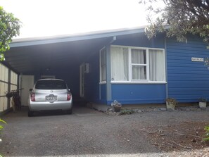Car port at the top of the driveway. Front door at end of carport on the righ