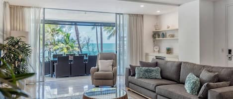 Relax in the open-plan living area with beach views and direct balcony access.