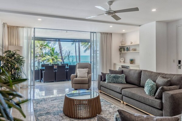 Relax in the open-plan living area with beach views and direct balcony access.