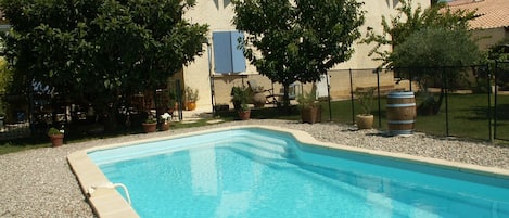 La piscine cloturée devant la terrasse ombragée