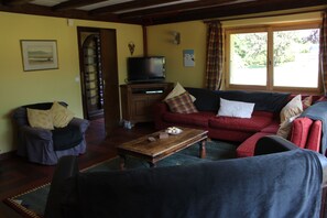 Sitting room looking towards the entrance hall with plenty of comfortable sofas.