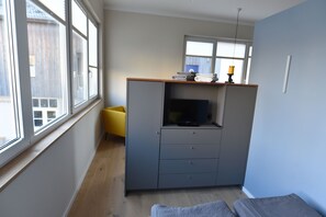 Raumteiler mit TV und Kleiderschrank vom Bett aus gesehen