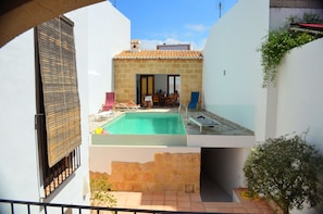 View from the kitchen terrace - pool and outdoor dining area with pizza oven