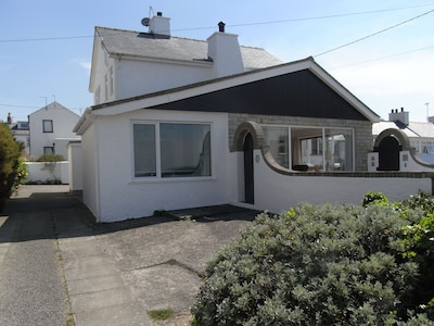 Bright modern holiday cottage steps from the beach and in the heart of village