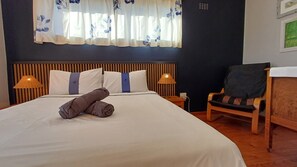 Main bedroom with queen-size bed, ceiling fan and balcony. 