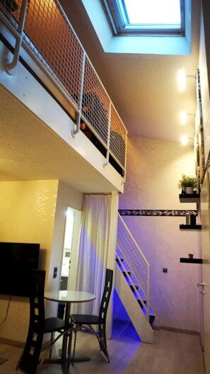 Illuminated stairs to the upstairs sleeping area and door to the bathroom