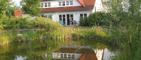 Rückseite Haus mit eingezäuntem Teich