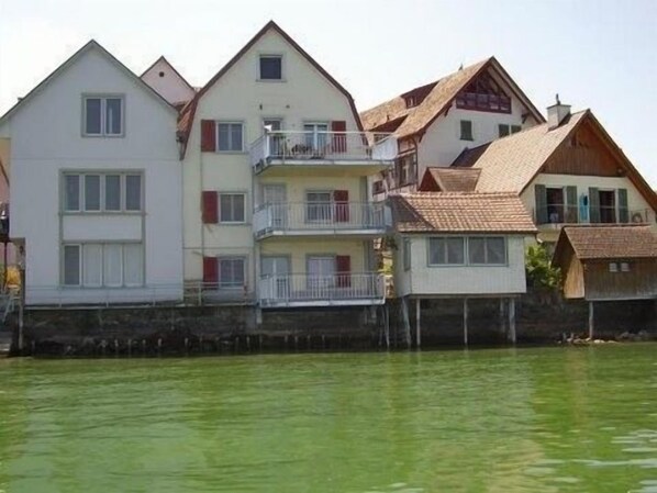 Blick vom See auf Gebäude mit der Wohnung im 1. Stock und Saunahaus 