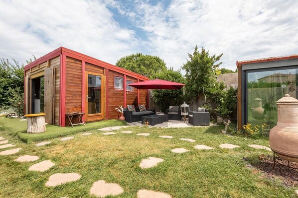 Salon extérieur exposé sud ouest, entre le chalet et la cuisine d'extérieur